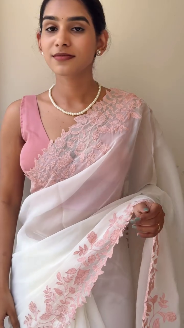 White Organza Saree with Intricate Baby Pink Floral Embroidery, Paired with Matching Pink Blouse and Pearl Accessories – Perfect for Festive, Wedding, or Traditional Occasions