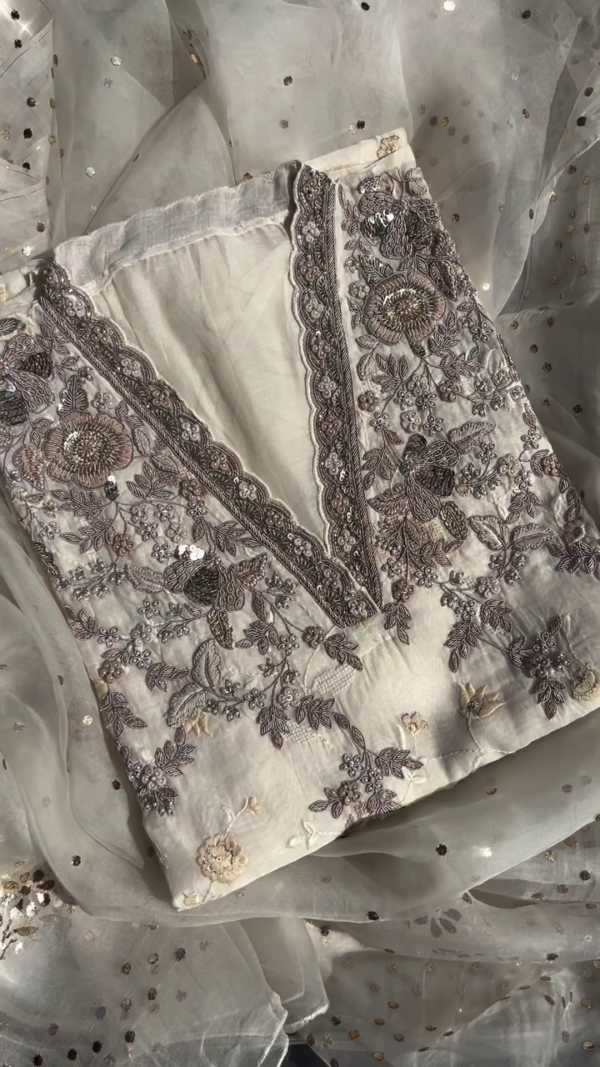 Off-White Chiffon Embroidered Unstitched Suit with Intricate Handwork, Sequins Detailing, and Floral Thread Embellishments Paired with a Sheer Net Dupatta Accented by Golden Polka Dots – Ideal for Festive and Formal Occasions