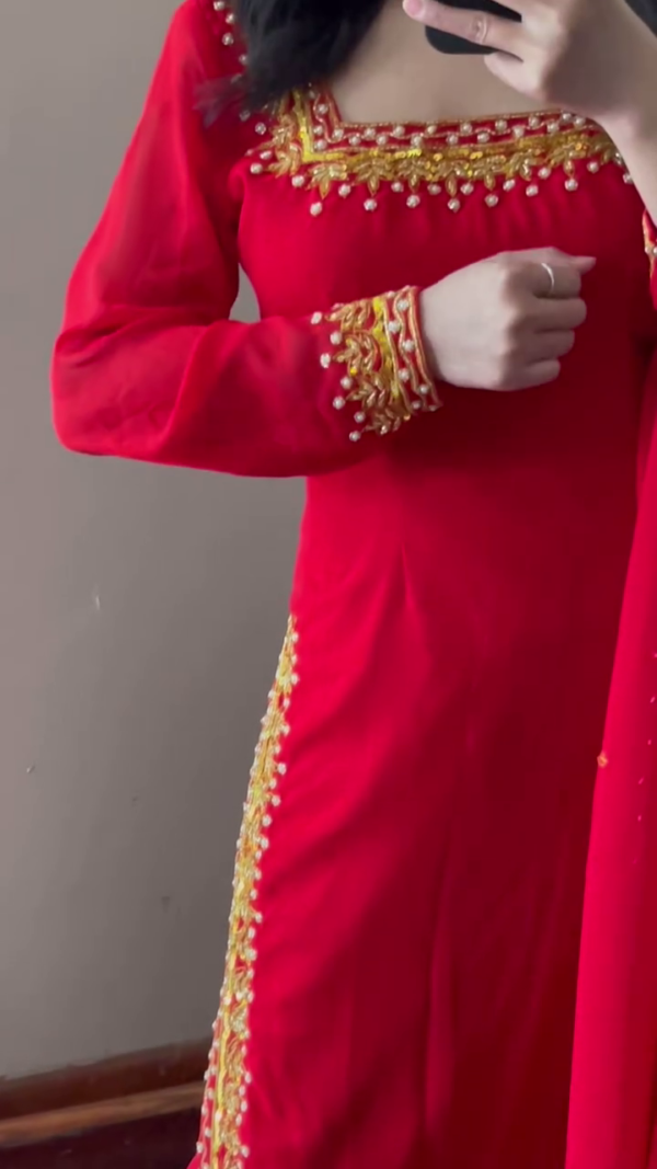 A stunning red ethnic outfit with intricate golden embroidery along the neckline, sleeves, and pant hems. The ensemble is complemented by a matching dupatta - Image 2