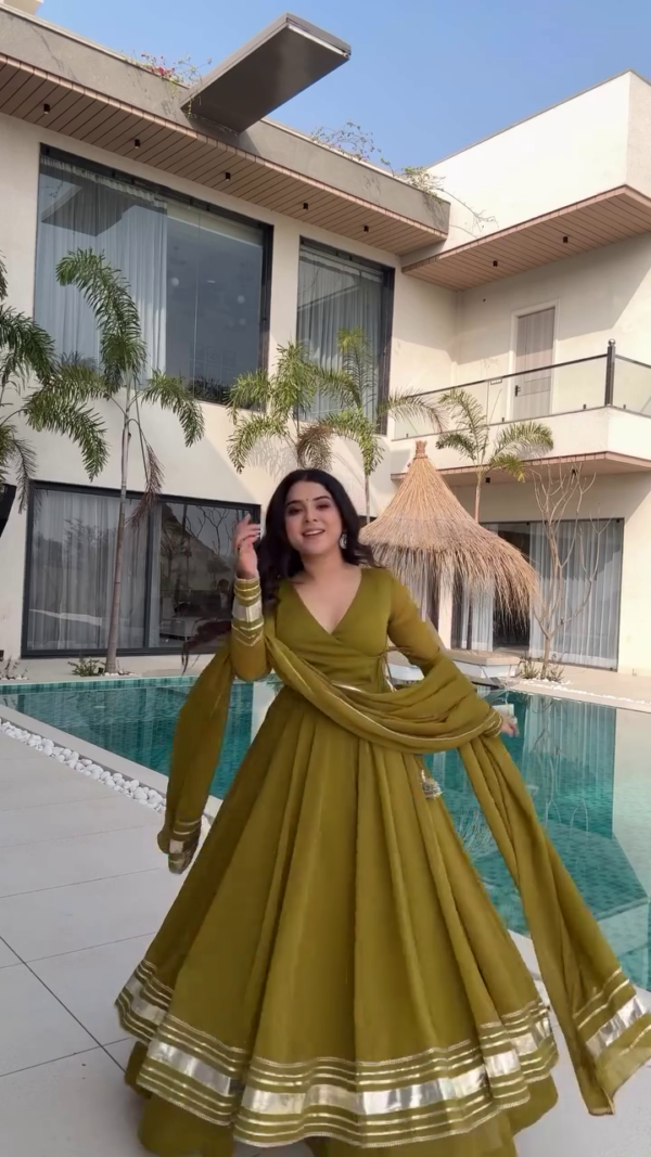 Radiating Elegance in a Beautiful Olive Green Anarkali Dress with Gold Detailing, Twirling Gracefully by the Poolside in a Stunning Modern Outdoor Setting