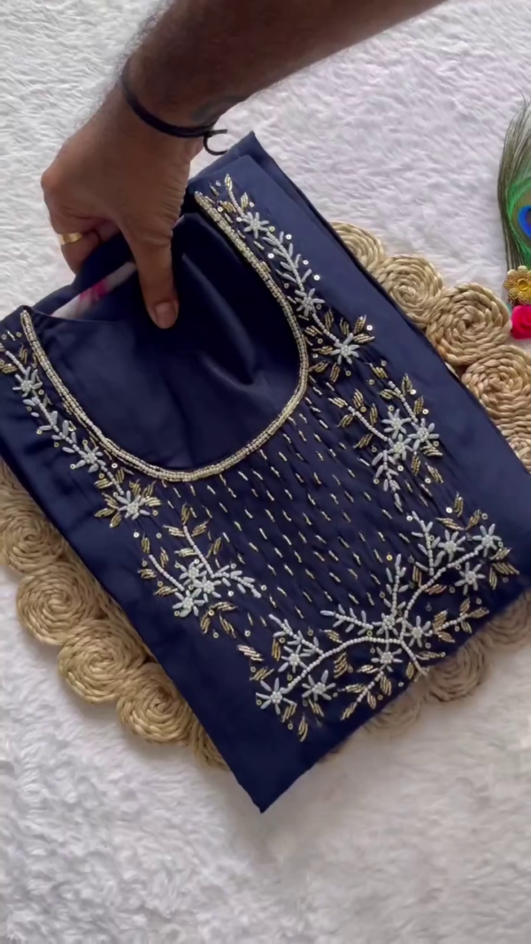Elegant Navy Blue Suit Set adorned with delicate silver embroidery on the neckline. Paired with a soft floral organza dupatta featuring vibrant multicolor blossoms and a golden border.