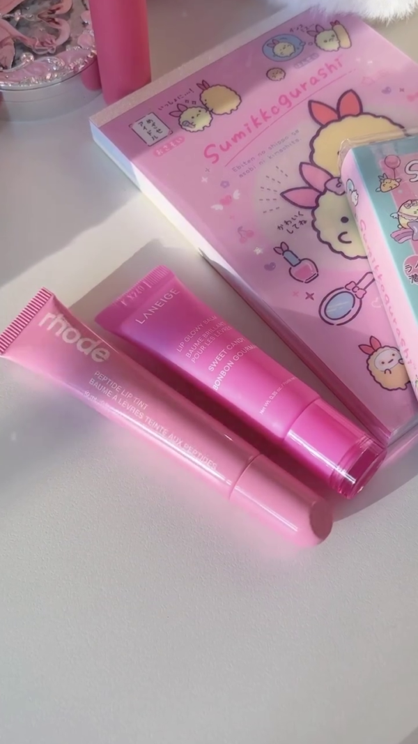 A pretty pink lip tint from Rhode, giving a soft, natural flush of color with a glossy finish. The packaging is simple yet sleek, and the product offers a light, buildable tint perfect for a subtle lip look.