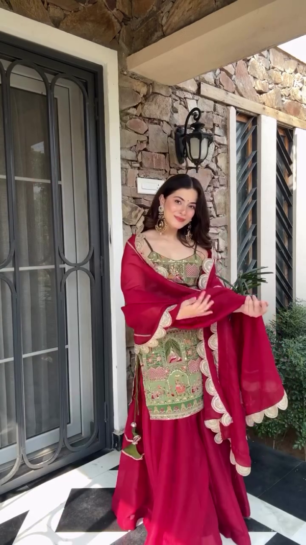 A stunning green and red ethnic outfit featuring intricate embroidery, paired with a matching dupatta, creating a beautiful blend of traditional and contemporary style, perfect for festive occasions.