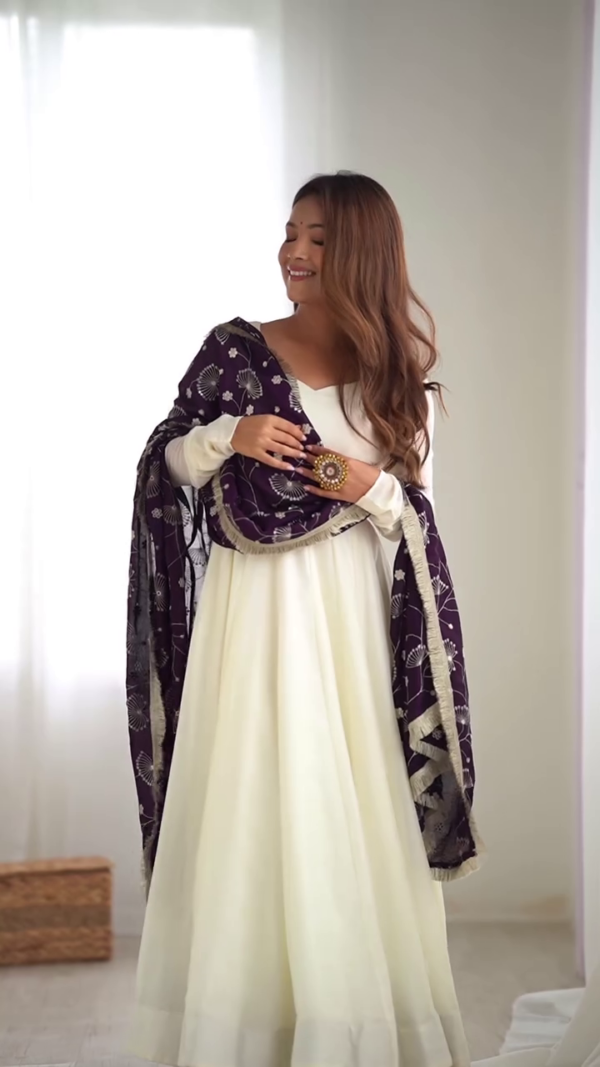 Elegant ivory Anarkali paired with a deep plum dupatta for a royal contrast. A timeless silhouette that radiates grace and festive charm.