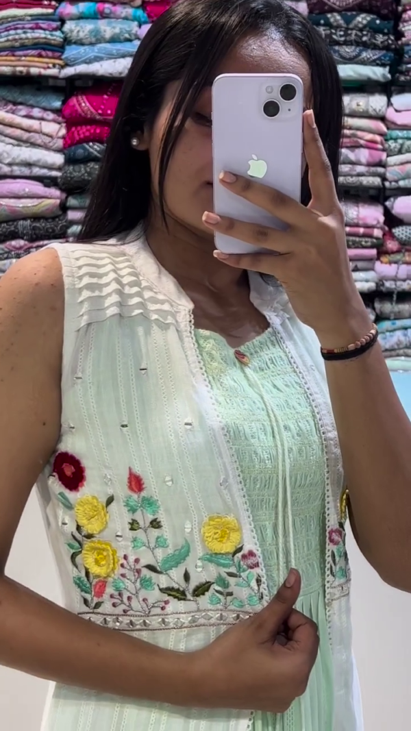 A breezy pastel green sleeveless dress layered with a white embroidered jacket, featuring delicate floral threadwork. Perfect for casual summer outings or festive day events with a touch of charm and comfort. - Image 2